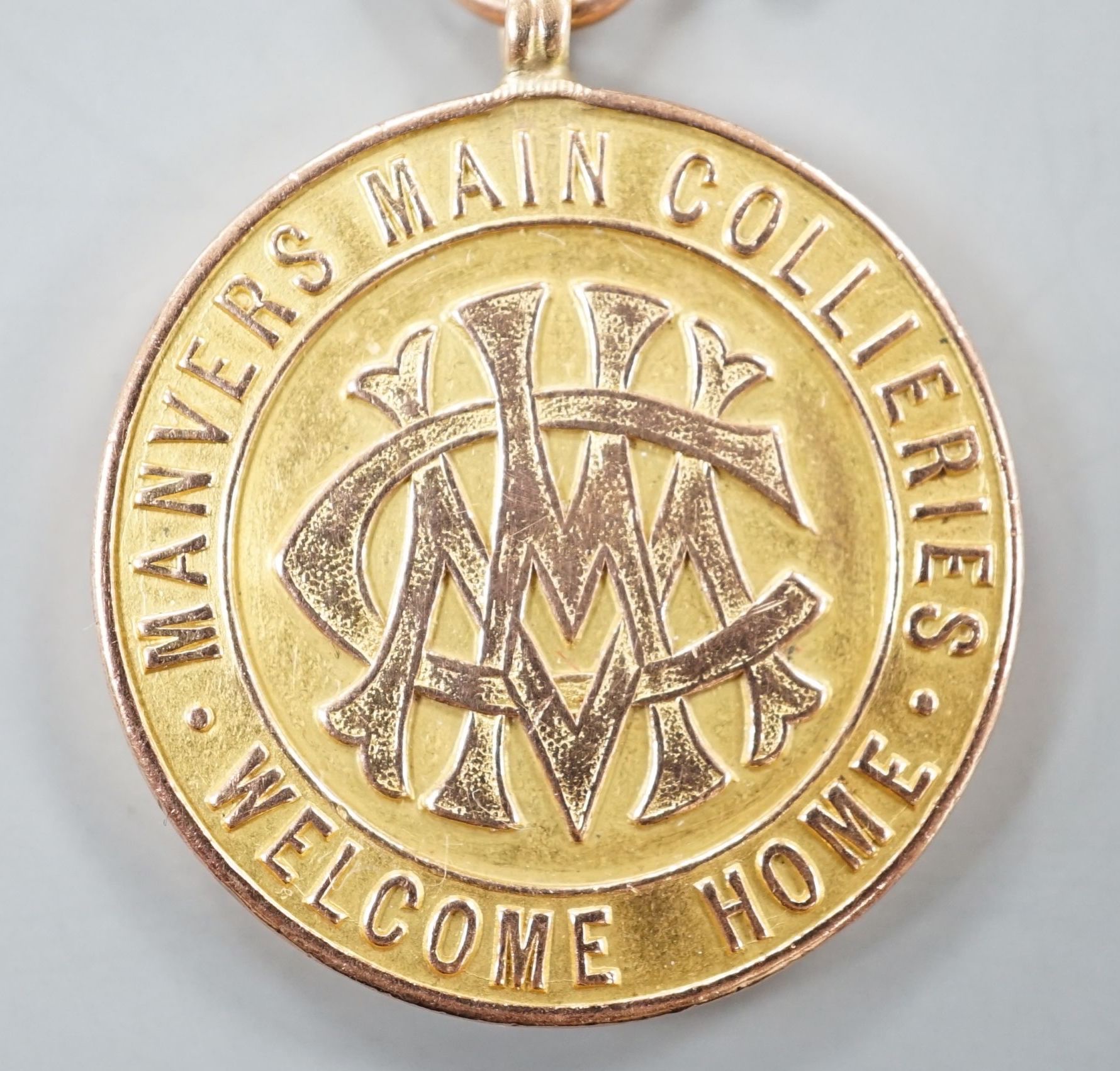 A WW1 related 9ct gold 'Manvers Main Collieries Welcome Home' medallion, presented to W.H. Cavanagh, 26mm